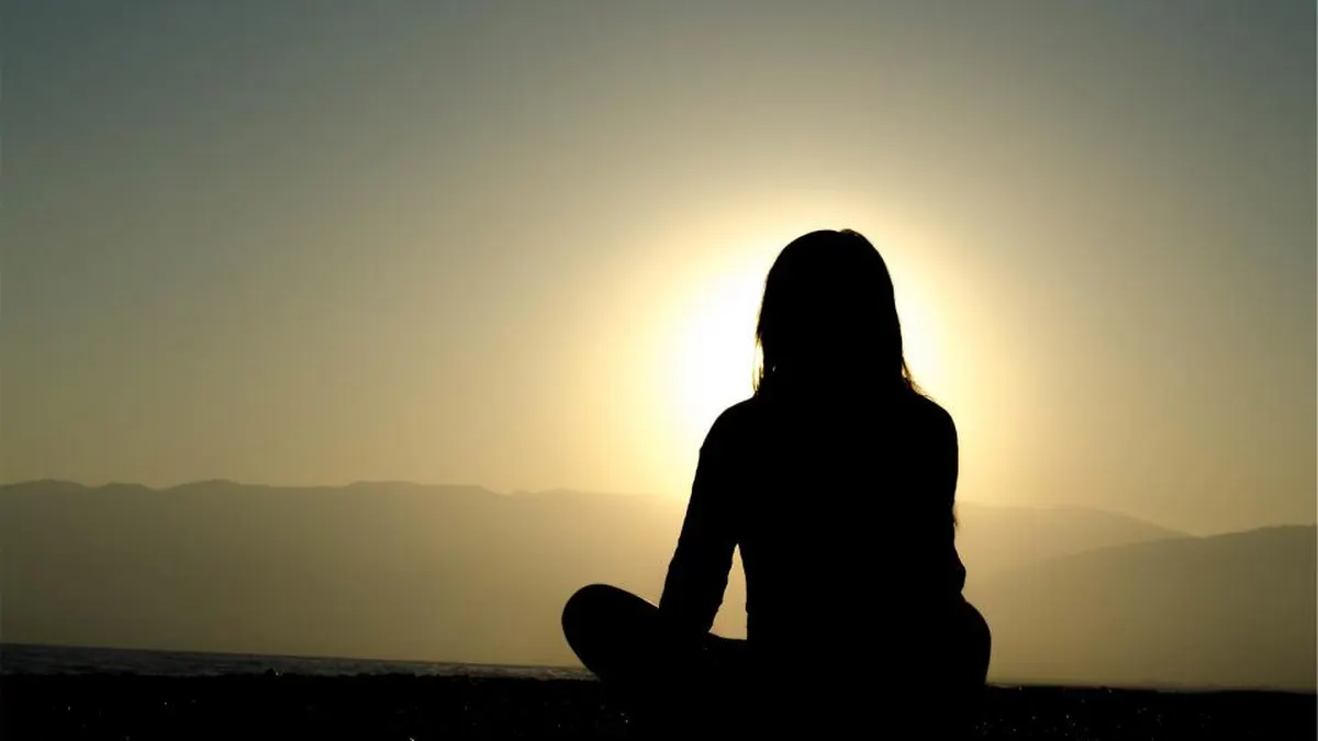 Meditierende Silhouette bei Sonnenuntergang