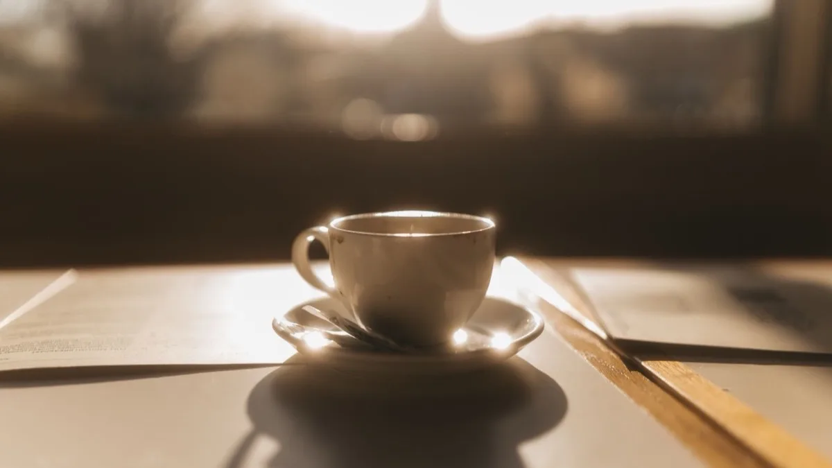 Tasse Kaffee am Fenster im warmen Morgenlicht