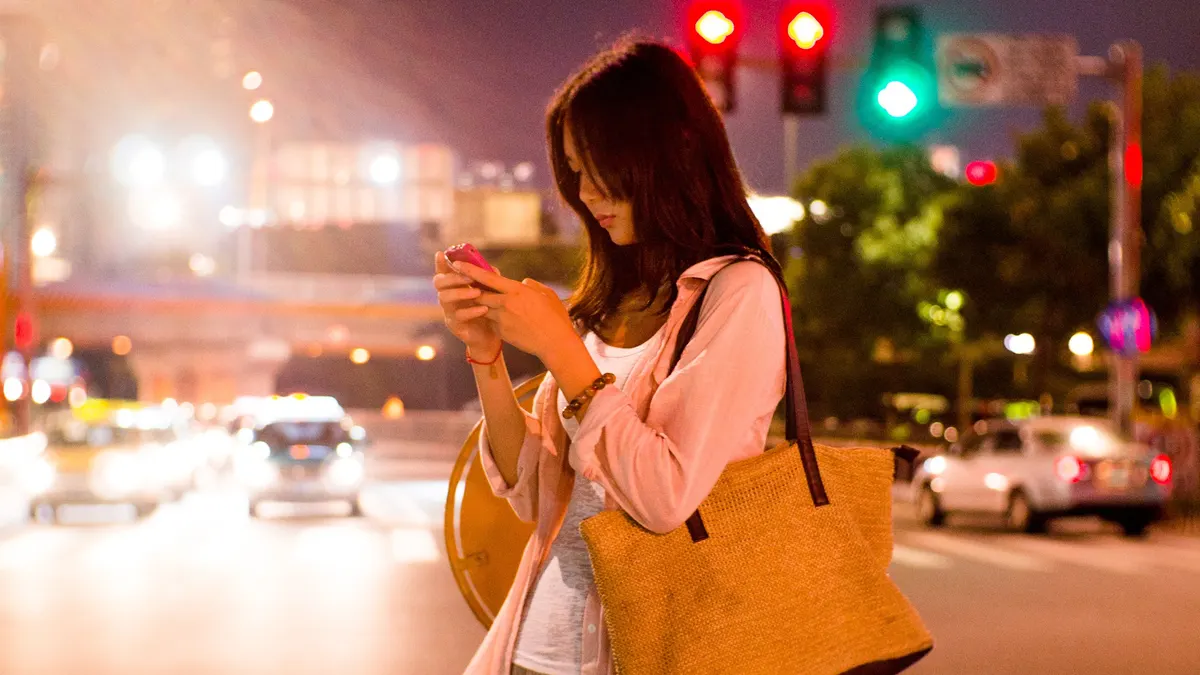 Frau schaut abends auf ihr Smartphone